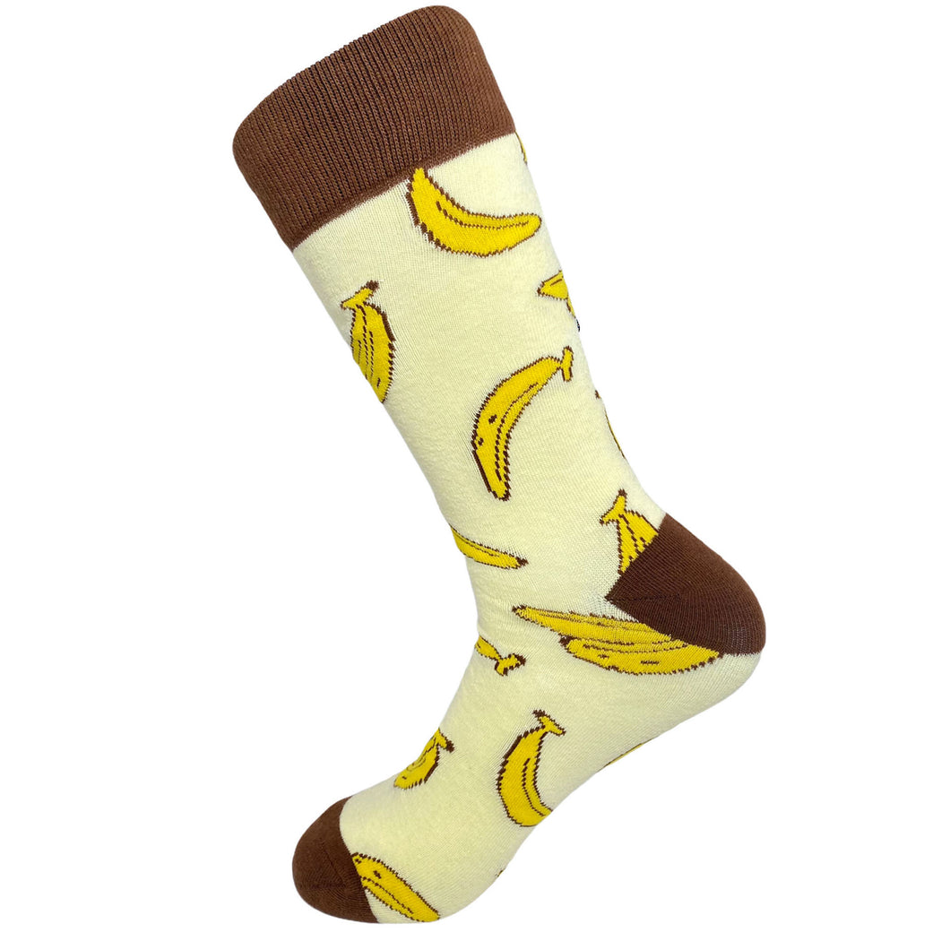 A pair of men's fun novelty eclectic socks that features an all over banana print with a brown contrasting accent on the top, heel, and toe. Resembles banana pudding.