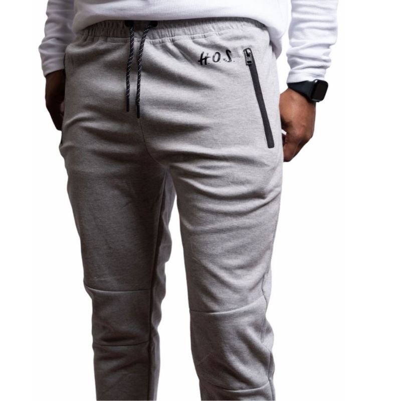 A comfortable heather grey slim mens fitted jogger pants. Features drawstring with zippered front pockets and leg cuffs. These joggers are part of the mens H.O.S. collection from House Of Shon.